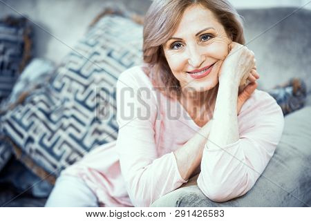 Elegant Woman Over 50 Years Old Cute Smiling. She Sitting On The Couch In The Living Room To Rest. C