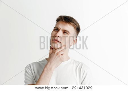 Looking For The Best Moment. Young Dreaming Smiling Man Is Waiting For Chanses Isolated On Gray Back