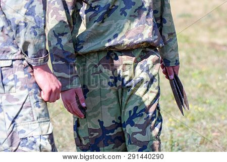 A Soldier In Camouflage Holding Throwing Knives