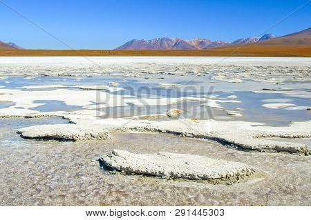 Frozen Lagoon Of Altiplano With Mountain Peak On Background. Bolivia, South America