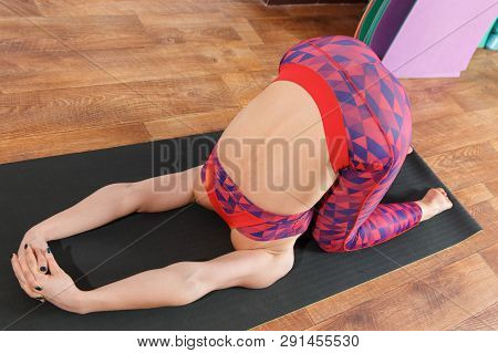 Young Sporty Woman Practicing Yoga, Doing Mahamudra Stretching Position In A Fitnes Club