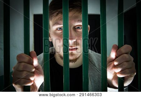 Jailed Young Man Behind Bars In A Cell