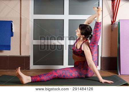 Young Sporty Woman Practicing Yoga, Doing Mahamudra Stretching Position In A Fitnes Club