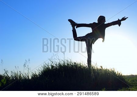 Teenage Girl In A Balancing Yoga Position. Young Girl  Outdoors. Fitness Yoga. Woman Stretching.