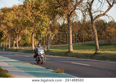 Bearded Biker In Sunglasses, Helmet And Black Leather Clothing Riding Cruiser Powerful Motorcycle Al