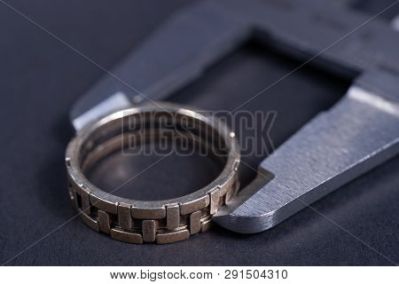 Vintage Steel Caliper Measuring Sterling Silver Male Ring Closeup. Ring In Focus. Tool In Very Good 