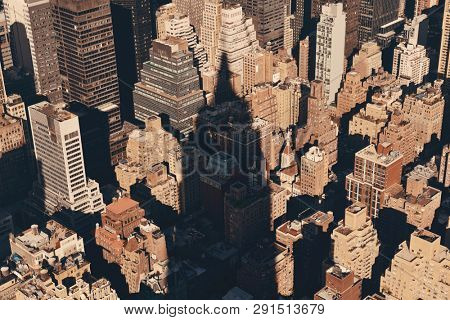 New York City - SEP 11: Empire State Building shadow over urban buildings on September 11, 2015 in New York City. With 8.5M, it is the is the most populous city in the United States.