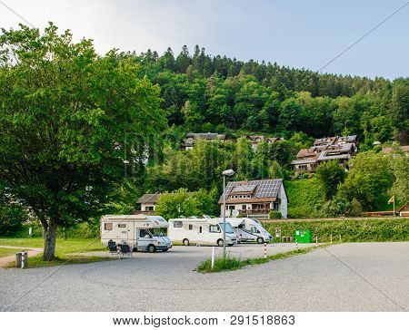 Schiltach, Germany - Jul 10, 2018: Couple Resting In Chaise Longue Chairs In Front Of Multiple Rv Ca