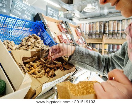 Woman Shopping For Fresh Turmeric Curcuma Flowering Plant Of The Ginger Family, Zingiberaceae Rhizom