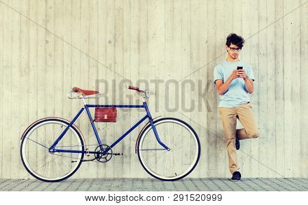 people, communication, technology, leisure and lifestyle - hipster man with smartphone and fixed gear bike on city street