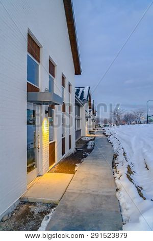 Pathway Along Homes And Snowy Ground In Winter