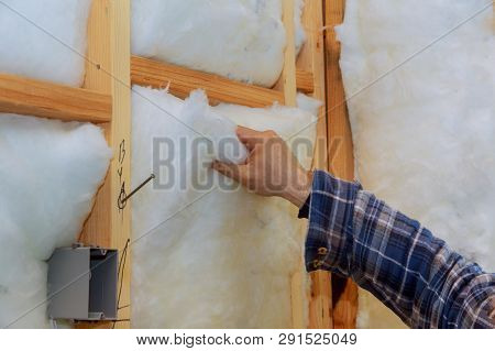 Worker In Insulating Rock Wool Insulation In Wooden Frame For Future House Walls For Comfortable War