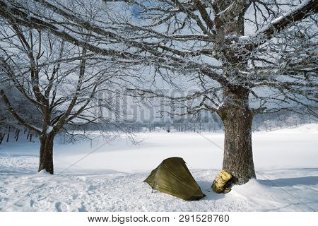 a tent and backpack by frozen lake in Nebrodi Park, Sicily