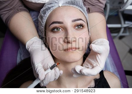 Permanent Makeup For Eyebrows. Microblading Brow. Beautician Doing Eyebrow Tattooing For Female Face