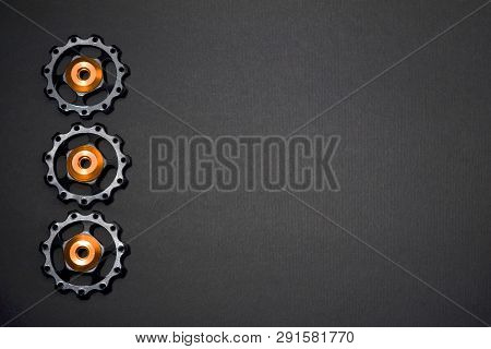 Color Rollers, Black, Golden Gears For Bicycle Rear Derailleur On Gray Background In Left Side, With