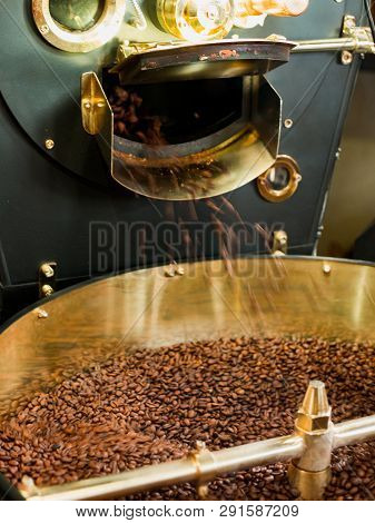 Roast Machine, Frozen Moment. The Freshly Roasted Coffee Beans From A Coffee Roaster Being Poured In