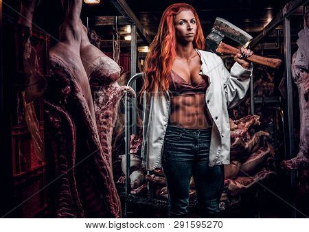 Strong Fitness Woman Wearing Unbuttoned White Shirt Posing With Ax In A Refrigerated Warehouse In Th