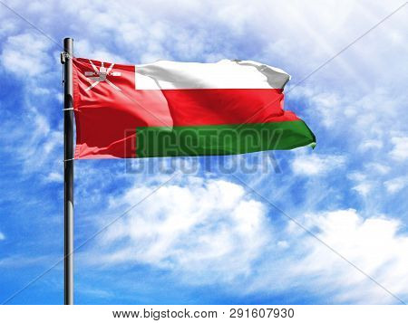 National Flag Of Oman On A Flagpole In Front Of Blue Sky.
