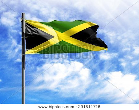 National Flag Of Jamaica On A Flagpole In Front Of Blue Sky.