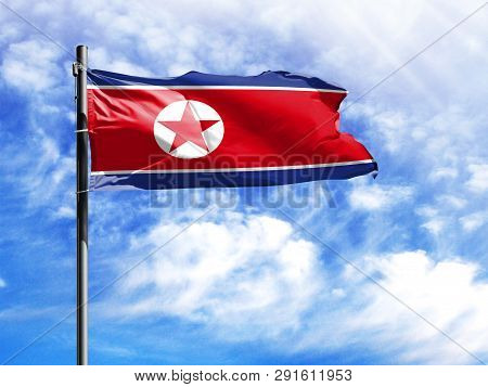 National Flag Of North Korea On A Flagpole In Front Of Blue Sky.