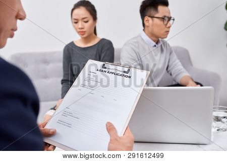 Young Angry Couple Of Cheated Investors Holding Papers Arguing With Male Real Estate Agent, Defraude