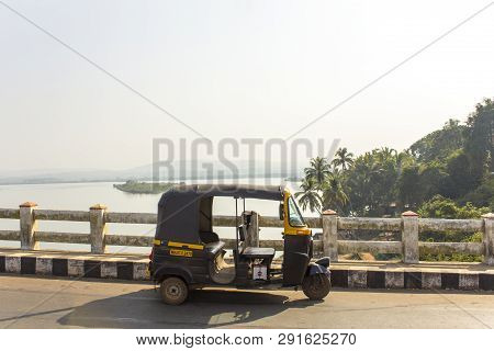 Querim, Goa/india - 10.01.2019: Indian Rickshaw Taxi Stands On A Bridge Against The Background Of Th