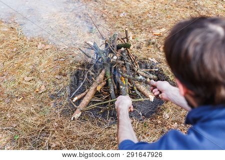 Bonfire In The Spring Forest On The Background Of Withered Grass. In The Frame Head, Shoulder And Ar