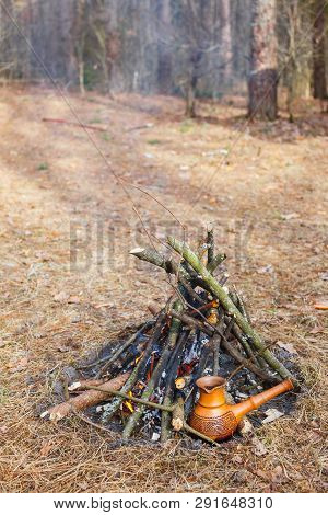 At The Stake In The Spring Forest, A Clay Turkish Coffee Pot Is Heated Against The Grass.
