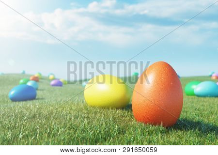Colorful Eggs In A Meadow On A Sunny Day Against The Blue Sky. Multicolored Painted Easter Eggs On G