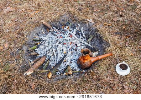 At The Stake In The Spring Forest, A Clay Turkish Coffee Pot Is Heated Against The Grass.