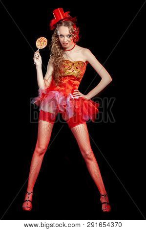 Sexy Burlesque Dancer Stripper Posing With Sweet Lollipop, In Red Corset And Red Hat With Curly Hair
