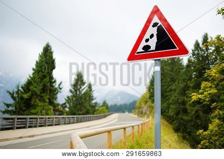 Falling Rocks Road Sign On Winding Road In German Alps. Warning Road Sign In The Mountains. Bavaria,