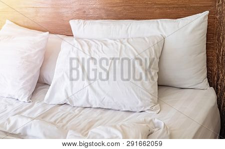 Pillows On The Bed With White Bedlinen And Wooden Bedhead