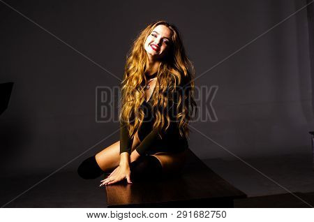 Beautiful Dancer. Girl Model. The Girl Sits In A Hat And Sits On A Table. Girl In A Beautiful Underw