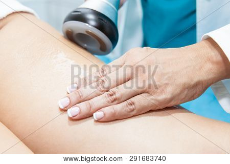 Doctor Performing An  Ultracavitation Treatment On A Young Female Patient Leg