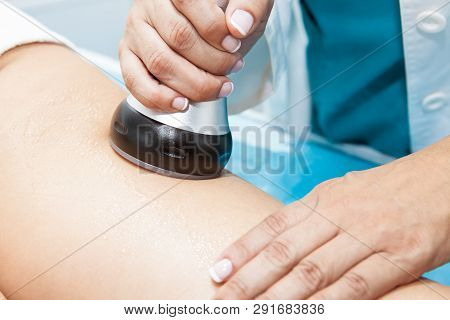 Doctor Performing An  Ultracavitation Treatment On A Young Female Patient Leg