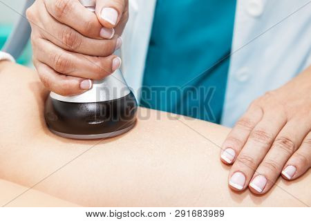 Doctor Performing An  Ultracavitation Treatment On A Young Female Patient Leg