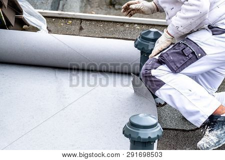 Construction Worker Using Tarpaulin As Covering Sheet To Protect The Ground