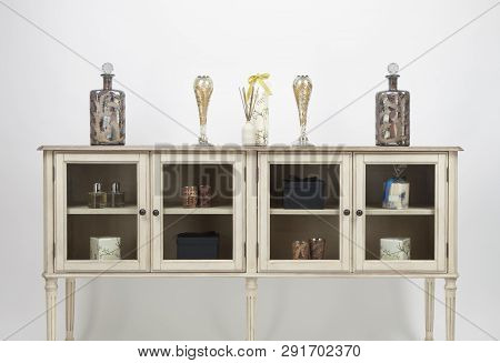 Glass Fronted Sideboard And Ornaments On A White Background