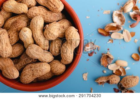 Natural Whole Peanuts In A Shell  On A Blue Background.peel The Peanut From The Shell.bank With Pean