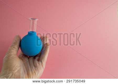 Female Hand With French Manicure In Medicine Glove Holds Blue Cosmetic Medical Jar For Vacuum Facial