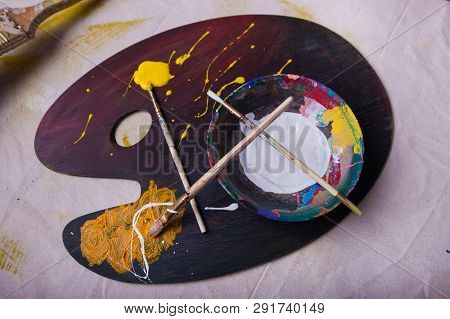 Wet Paint Three Artist Paintbruses On A Wooden Paint Mixing Palette