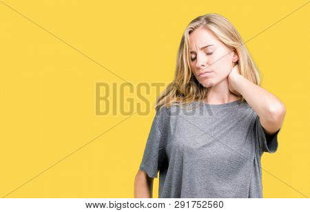 Beautiful young woman wearing oversize casual t-shirt over isolated background Suffering of neck ache injury, touching neck with hand, muscular pain
