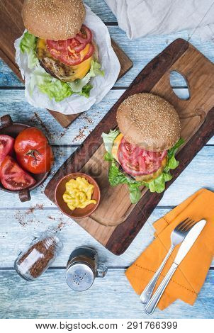 Burgers On A Table, Mustard And Tomato