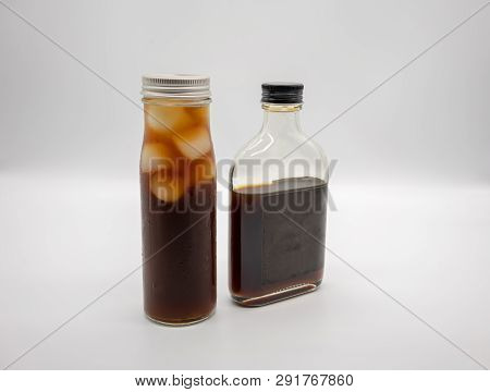 Cold Brew Coffee In Glass Bottle With Black Cap And Cube Ice In Cylinder Glass Bottle Isolated On Wh