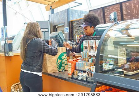 NEW YORK CITY, NY - CIRCA MARCH, 2016: woman pick up order at Starbucks in John F. Kennedy International Airport, New York.