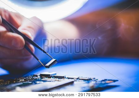 Man installing a chip onto the CPU board. Computer repair, IT service.