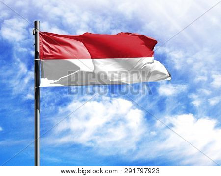 National Flag Of Indonesia On A Flagpole In Front Of Blue Sky.