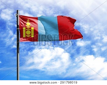National Flag Of Mongolia On A Flagpole In Front Of Blue Sky.