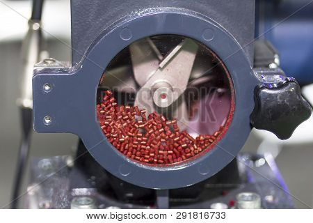 Close Up Red Plastic Granules In Crusher Machine With Blade Of Cutting Prepare Material For Injectio